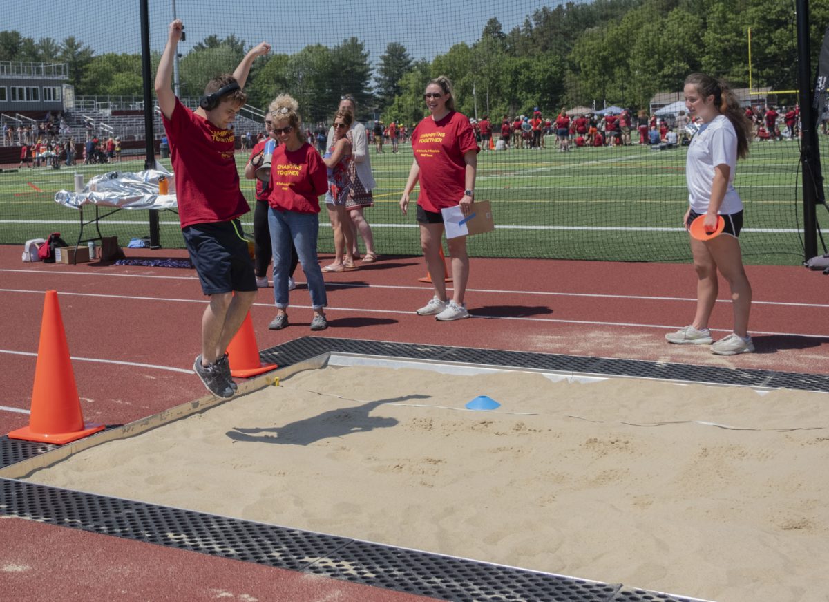 At the Titan Games on May 22, post-graduate Jayson Michaud takes a running start and jumps into the sand pit during the long jump.