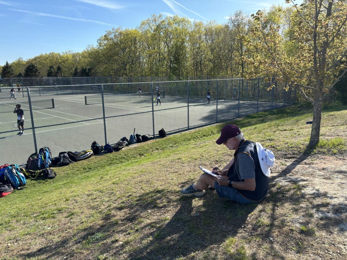 New boys tennis coach Chuck Bourke takes notes on the teams match against Shrewsbury on May 7.