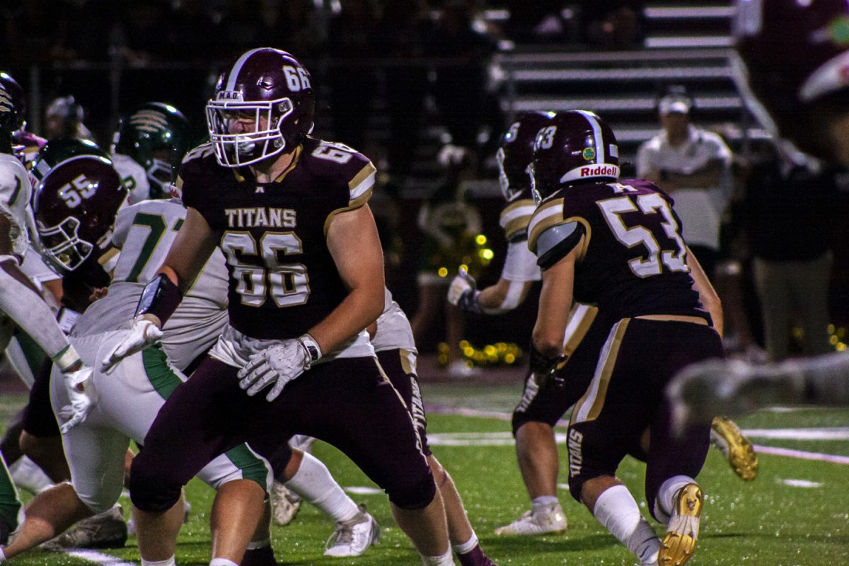 Sophomore Max Tolander (66) gets ready to tackle the incoming Nashoba player during the first football game of the season and the first back at the Richard Walsh Football Field.