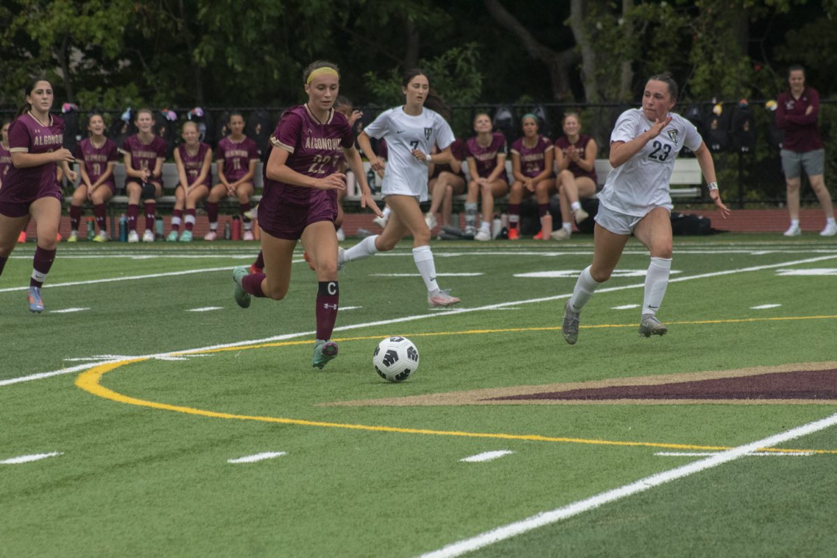 On Saturday Sept. 7, senior captain Olivia DeMember dribbles the ball against the Acton-Boxborough defenders.