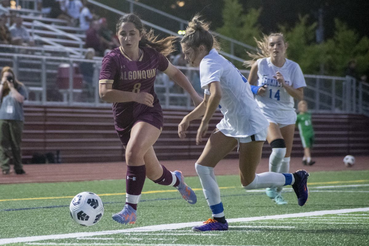 Junior Rebecca White (8) runs side by side with a Leominster opponent during Algonquin's 4-0 win on Sept. 10.