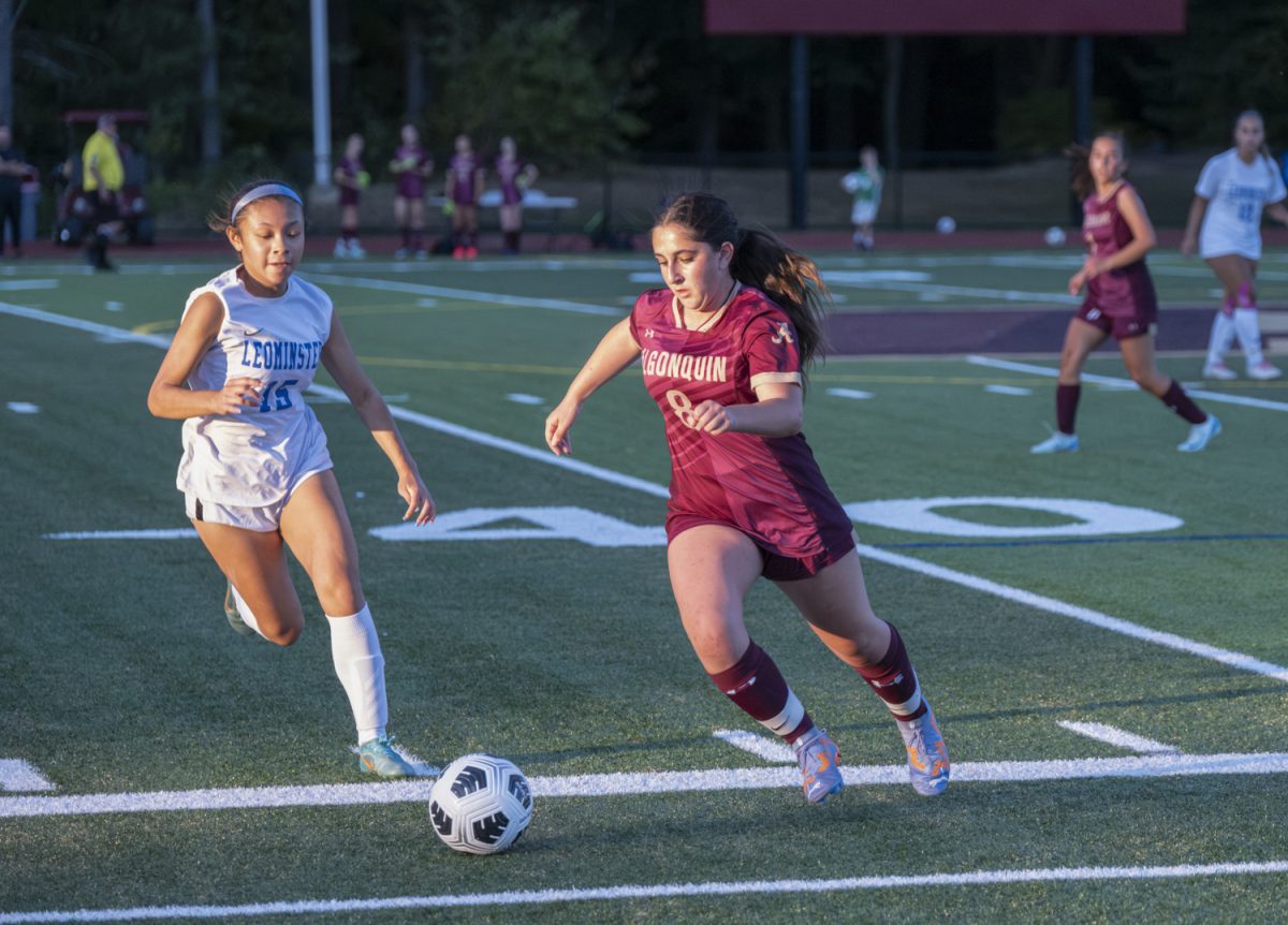 During the girls' varsity soccer game against Leominster on Sept. 10, junior Rebecca White races for the ball with the opposing team quick to follow.