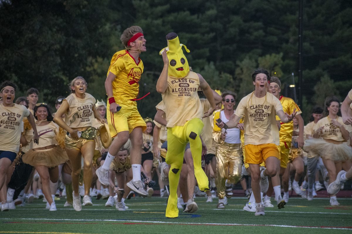 Seniors dress up for the theme "Gold Rush" and run across the football field to the bleachers before the football game on Sept. 13.