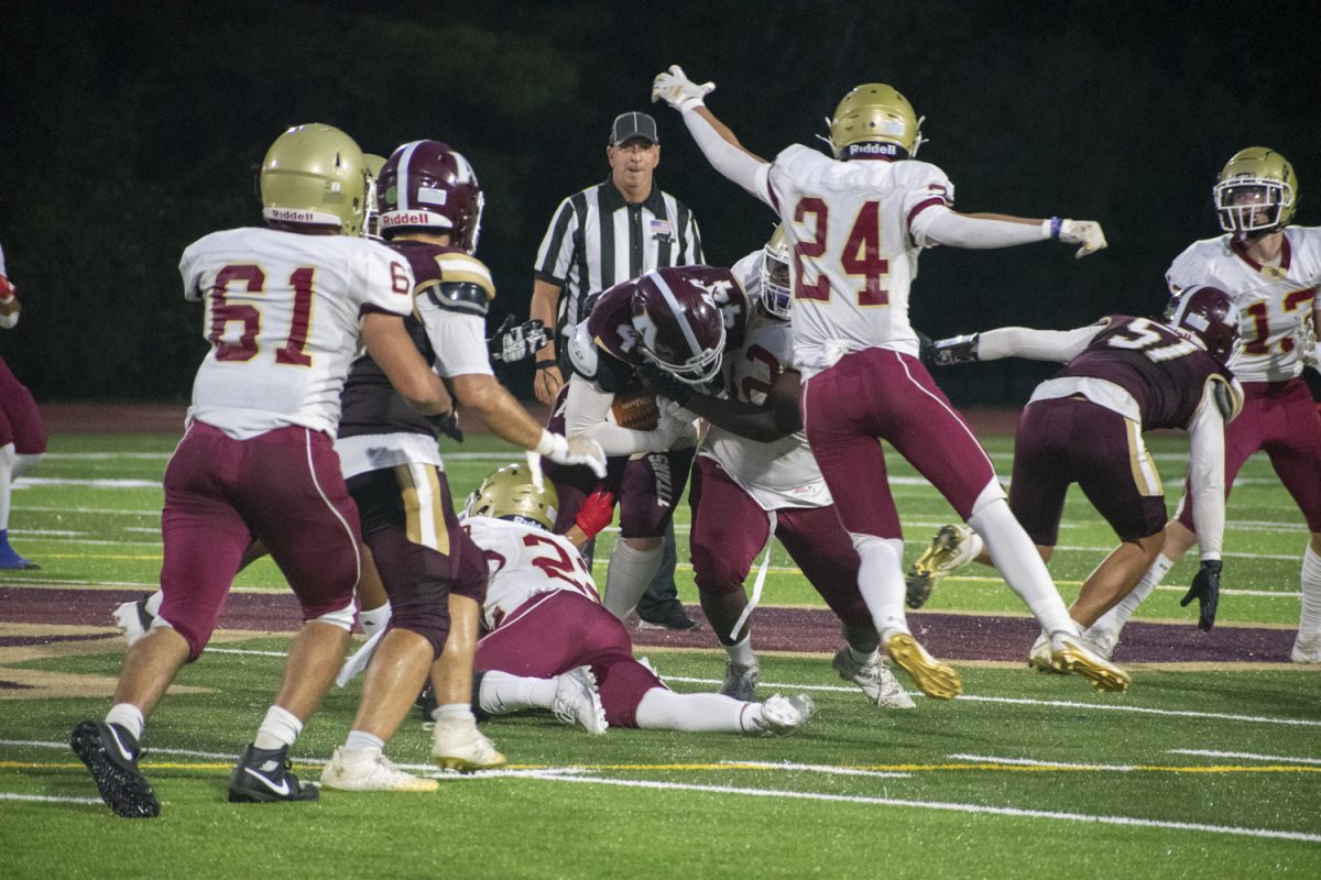 Senior captain Owen Ellsworth (44) is tackled by multiple Doherty opponents.