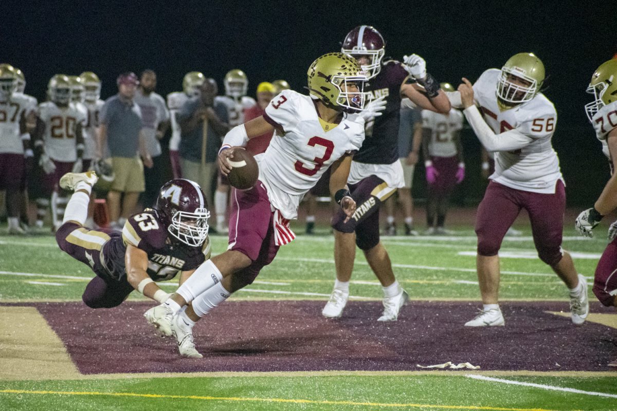 During their 31-14 loss against Doherty Memorial High School on Sept. 13, senior captain Kyriakos Ciccone (53) grabs the leg of a Doherty opponent.