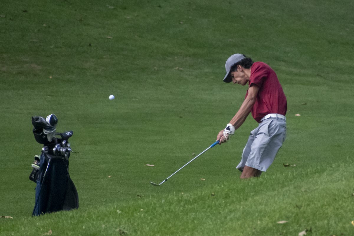 Senior George Skafidas hits the ball upwards towards the hole during the boys' varsity golf win against Leominster on Sept. 19.