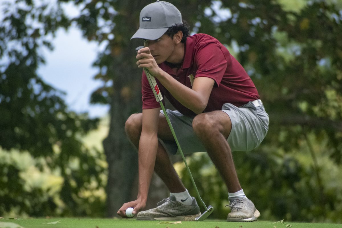 Senior George Skafidas lines up his putting shot during the boys' varsity golf win against Leominster on Sept. 19.