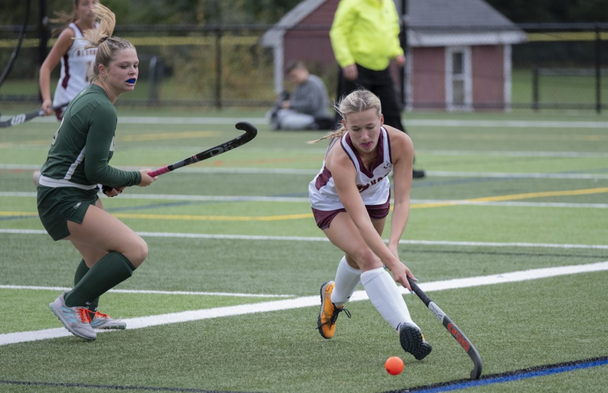 Junior Taylor Mieth keeps the ball away from her opponents during the field hockey game against Nashoba on Sept. 23. 