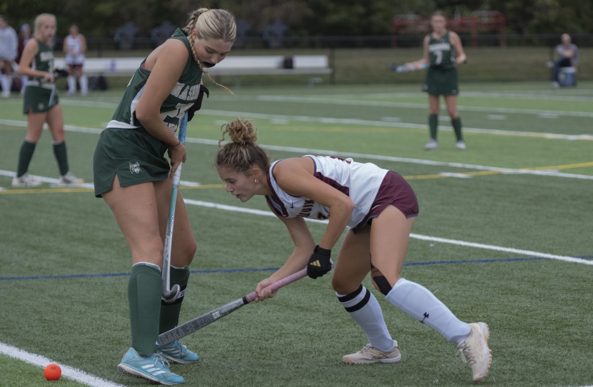 On Sept. 23, during a home field hockey game against Nashoba, senior Lindsey Brown hits the ball under an opposing teammate and towards her teammate. Algonquin wins 3-2 against Nashoba.