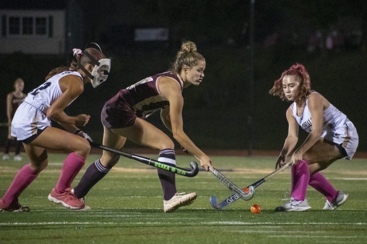 Senior Lindsey Brown fights for the ball against two opposing Shrewsbury players at the 2-0 winning game on Oct. 2.