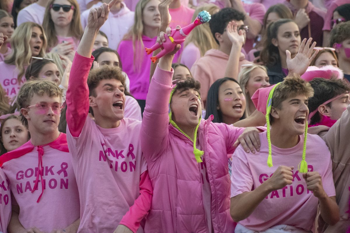 Senior Zachary Ruthfield (middle) yells out chants at the football game on Oct. 11.