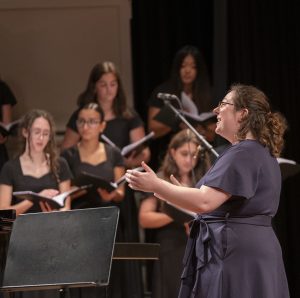 During the "Songs for the People" choral concert on Oct. 22, music teacher and concert director Olivia Goliger directs the concert choir.