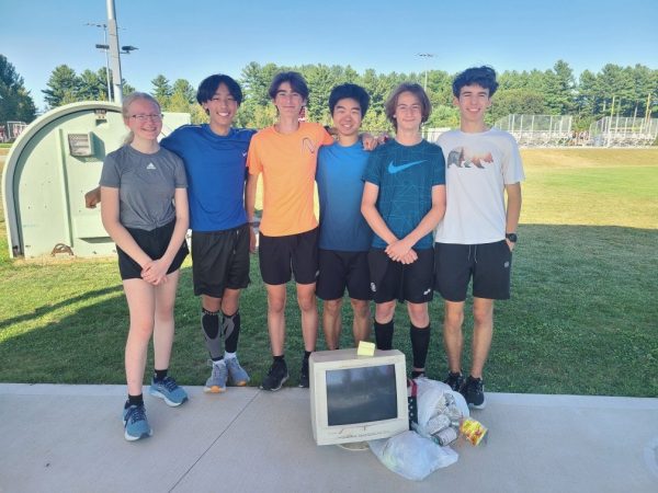 Members of the cross-country team stand by the trash they collected from the trails, which earned them the title of 'most unique trash' in the competition.