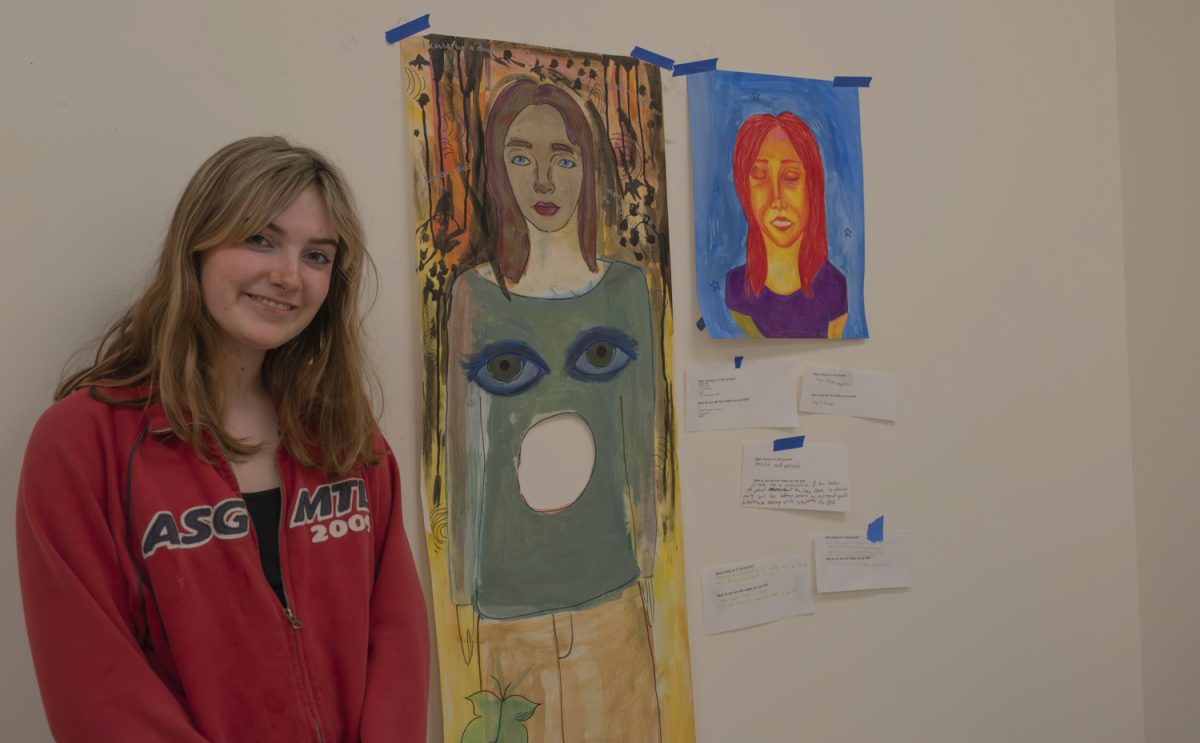 Senior Lila Shields poses with her artwork which she titled “ Radiance.”