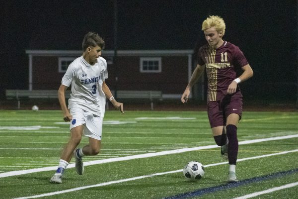 During a 2-1 wining game for Franklin, Algonquin senior Caden Hansen (11) runs along the field guarded by a Leominster defensive player senior Danny Reis (3) on Nov. 6.