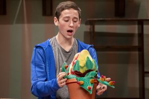 During rehearsals for Algonquin's fall musical, Little Shop of Horrors, sophomore AJ Phaneuf sings "Grow for Me" with the Audrey II puppet. During rehearsals, the sets are being constructed and the plant puppets are moving onto the stage.