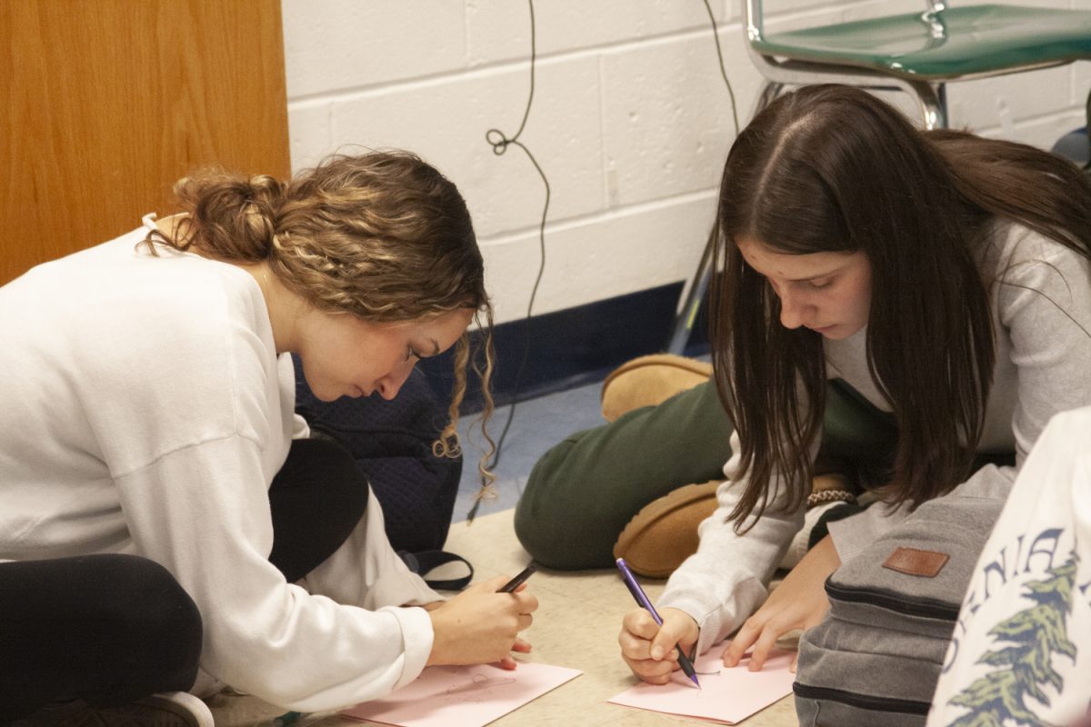 While attending a Create for Kids club meeting, juniors Kiera Akus and Sydney Dafoe spend their time making cards for hospitalized children.