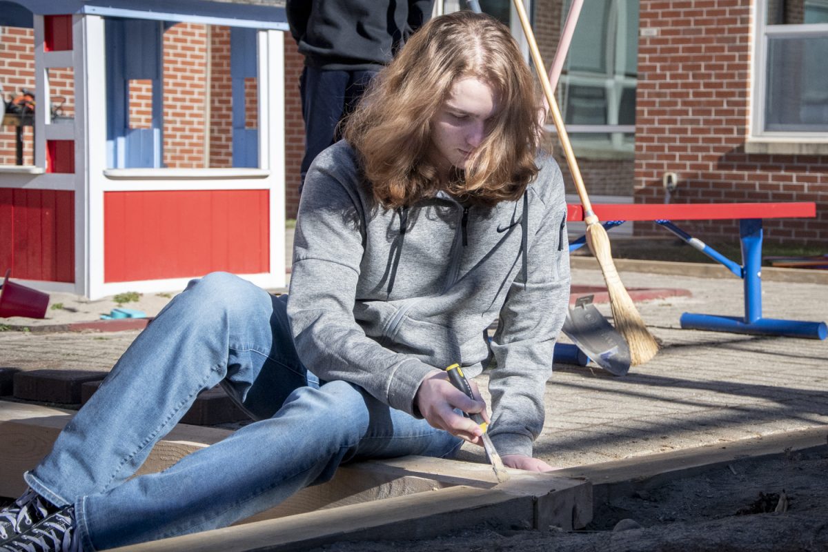 Senior Justin Plourde works on a project at the Tiny Titan’s Playground. The Hands-On Engineering Class is “building borders around the playground ‘cause the current ones are rotten and bad," sophomore classmate Akshaj Polavarapu said.