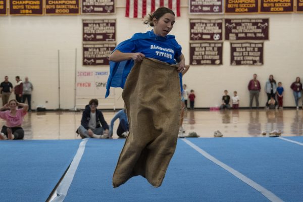 Junior Lily Dumont hops to the end of the cheerleading mat during the pep rally on Nov. 27.