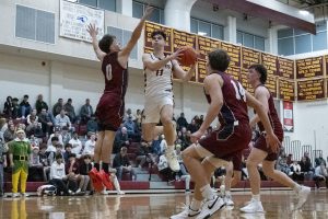 During Algonquin's 46-38 win on Dec. 12, senior captain Zach Ruthfield (11) jumps into the air to shoot the basketball while Westborough senior captain Alec DesRosiers (0) jumps to block him.