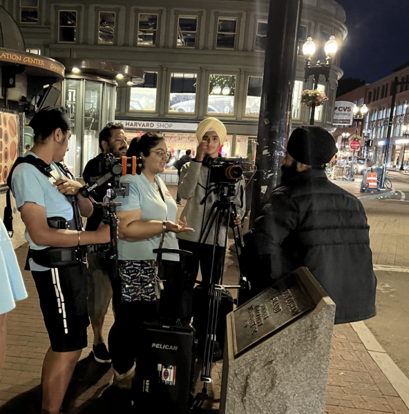 Senior Tanisha Kapoor talks with her film crew on the sidewalk while filming on location for her documentary "Baywatana."