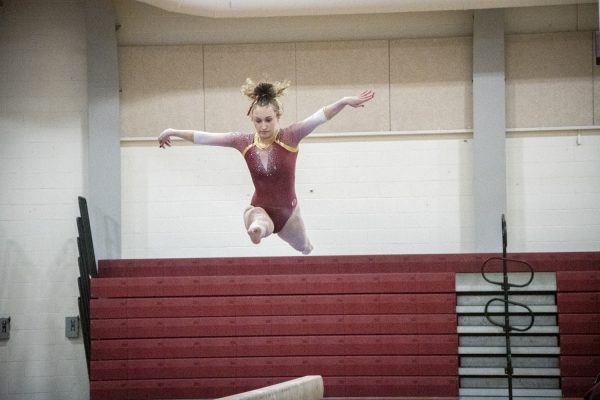 Junior Kiera Akus jumps during her performance on beam at a home gymnastics meet. On Jan. 2, Algonquin defeats Shrewsbury and Groton-Dunstable.