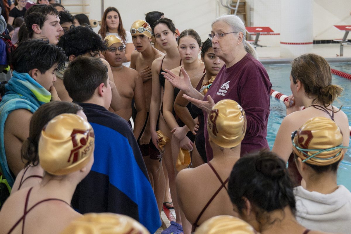 Coach Jean Fedak gives a pep talk before the start of the meet on Jan. 2.  The Algonquin girls' swim and dive team wins 96-76 and the boys' swim and dive team wins 101-72 against Shrewsbury.