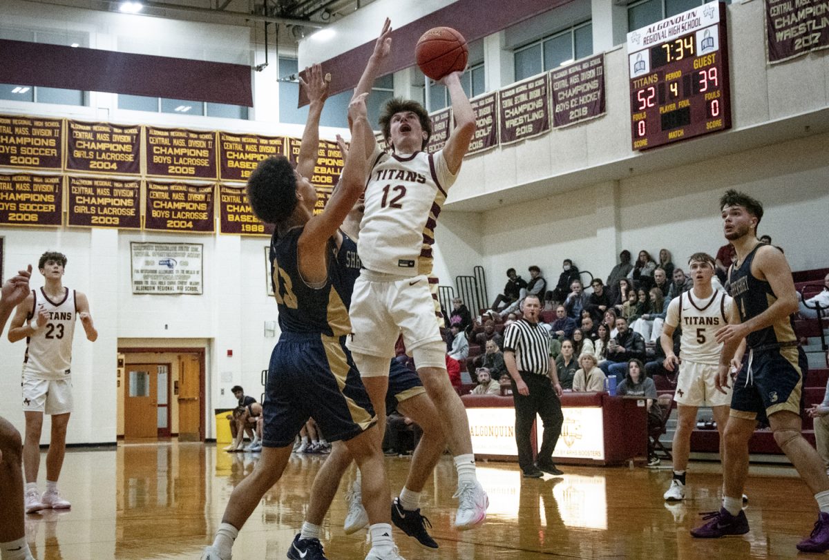 Junior Dylan Poirier (12) takes a shot while being guarded by Shrewsbury junior Sheron Brown (13) during Algonquin's 66-50 win.