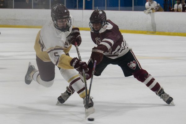 Senior Jared Walsh (5) fights against a Groton-Dunstable opponent during the first half of Algonquin's 7-0 winning game on Jan. 4.