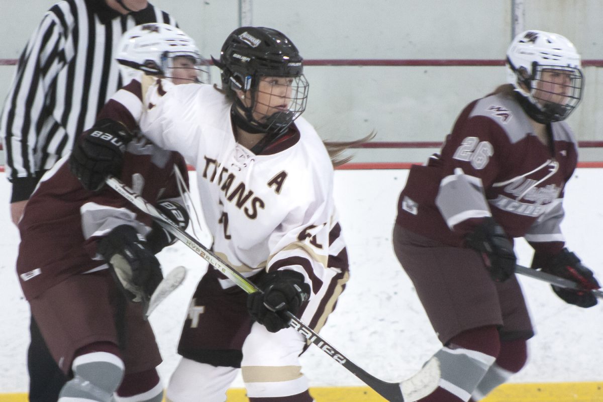 Senior Annabelle Biagini (21) stays focused as two Westford Academy players surround her, attempting to block her from receiving the puck during the girls' hockey game on Jan. 6. The game ended in a 1-1 tie.