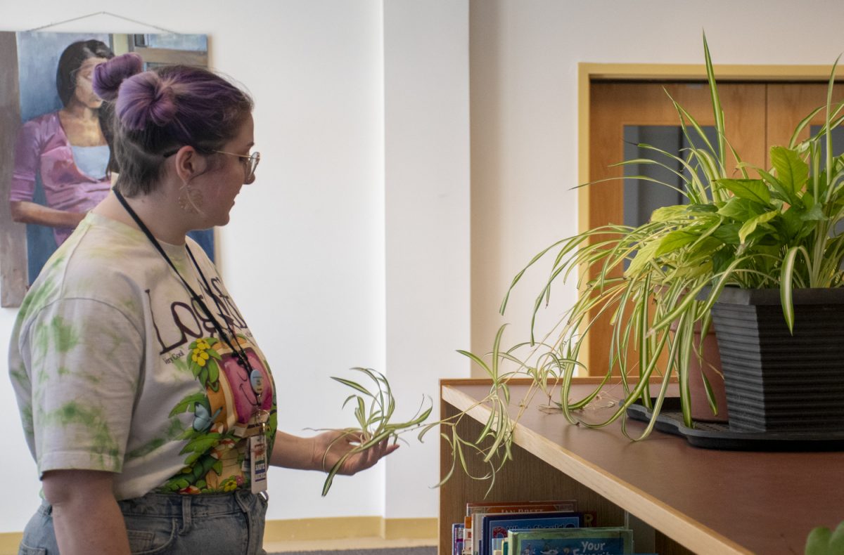 Library aide Bridget Richardson describes her knowledge of spider plants on Jan. 16. Around the Algonquin library, there are many plants on display.