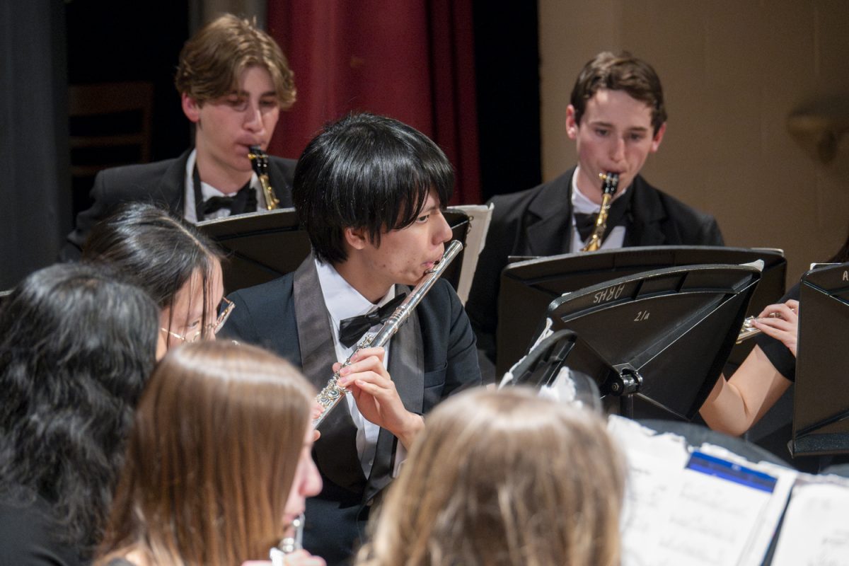 On the flute, senior David Wang performs in the wind ensemble during the MICCA showcase on April 8. Behind Wang, sophomores Ben Dane and AJ Phaneuf play the saxophone.