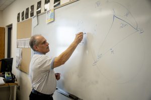 New Algonquin faculty member Robert Sternburg adds an equation to his classroom whiteboard on April 15. Sternburg joined Algonquin this previous winter as a math teacher.