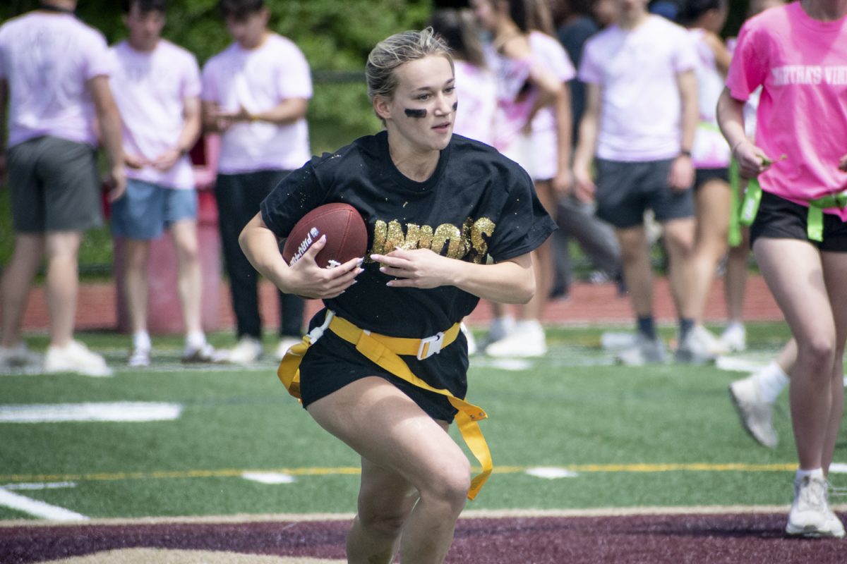 During the Powderpuff game on May 19, junior Taylor Mieth sprints with the football in hand. Powderpuff is a game where junior girls play against senior girls in flag football.