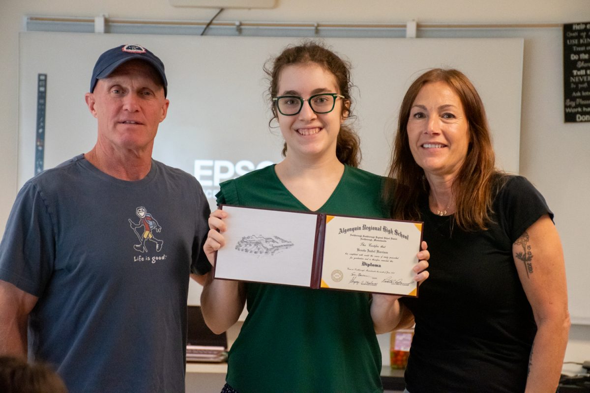 Postgraduate Brooke Harrison stands with her parents after being given her diploma signifying her graduation from Algonquin’s Community Access Program (CAP).