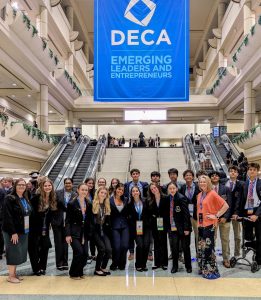 DECA students pose in front of DECA sign at the International Career Development Conference (ICDC) for their competition. 