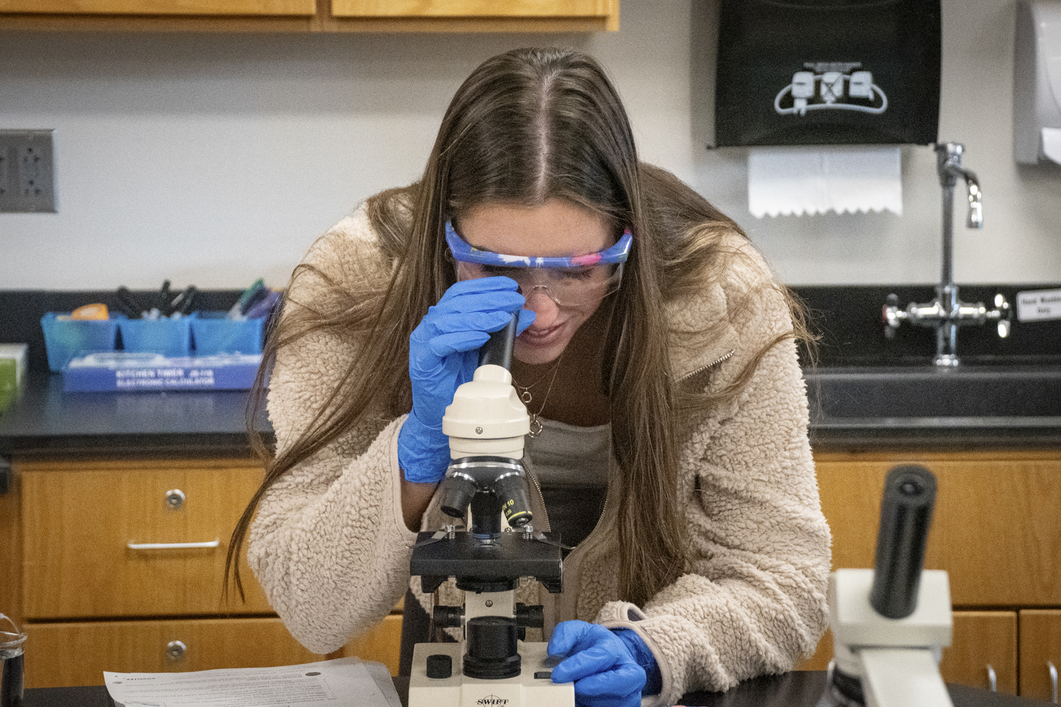 Senior Laurel Congdon-Hohman uses a microscope during an AP Biology class to examine cancer cells.
