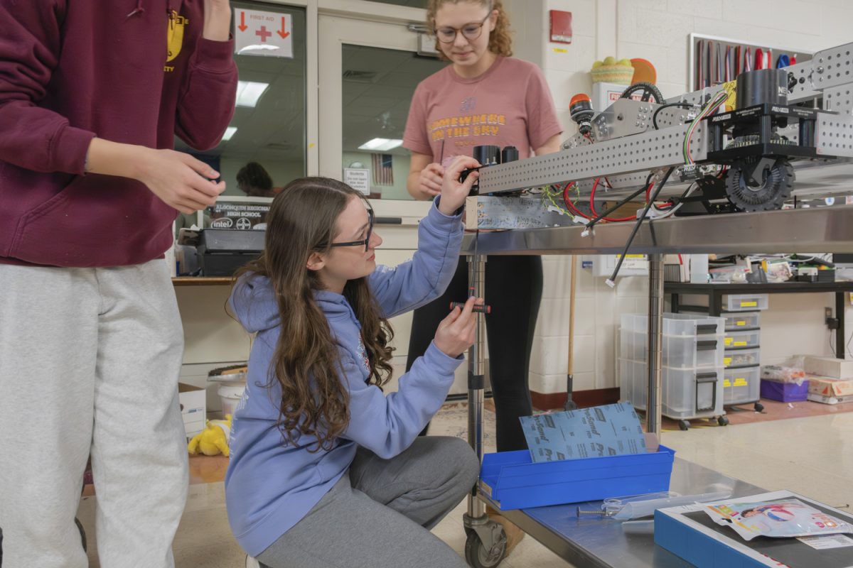 During one of the biweekly meetings of Algonquin's robotics club on Nov. 12, junior Caitlin Palmer helps fix misplaced screws on fellow member’s robots.