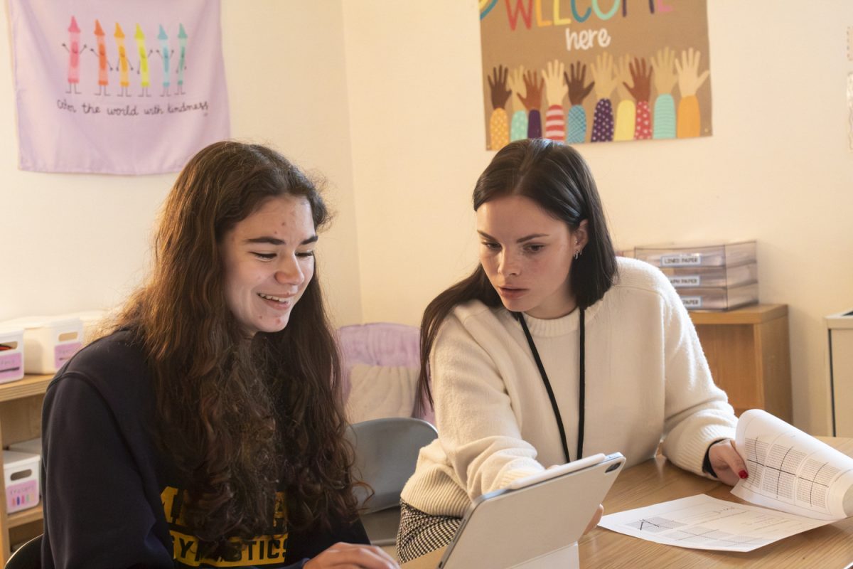 Special Education Teacher Colleen Mills helps junior Dylan Davidian with school work. Mills finds great enjoyment in finding specific ways to help different students.