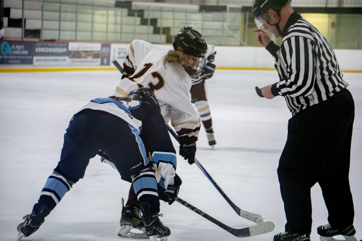 Freshman Kellyn York fights for the puck against an opponent during the win against Franklin on Feb. 9.