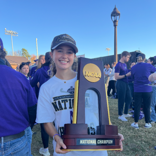 Alumna Lindsey Brown poses with the National Champion trophy after their big win against Princeton University. 