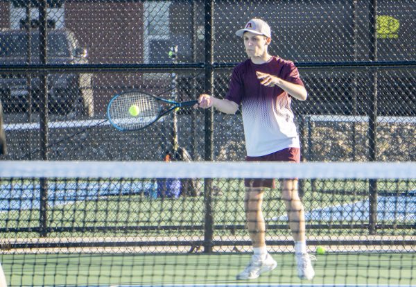 During the boys' tennis match, senior Jackson Stiles returns the ball.