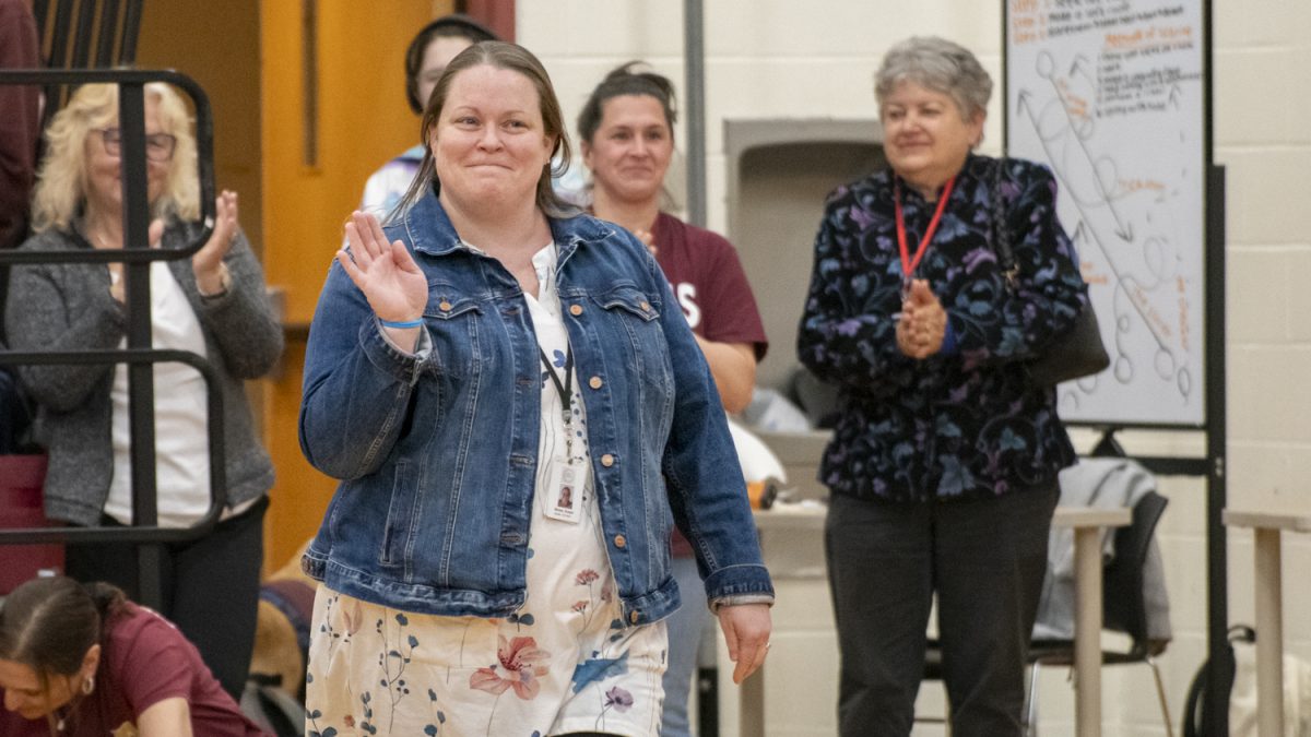 Applied arts teacher Susan Muise waves to cheering students when she is announced as the winner of the Pat Carlson teacher of the year award during the assembly on May 8.