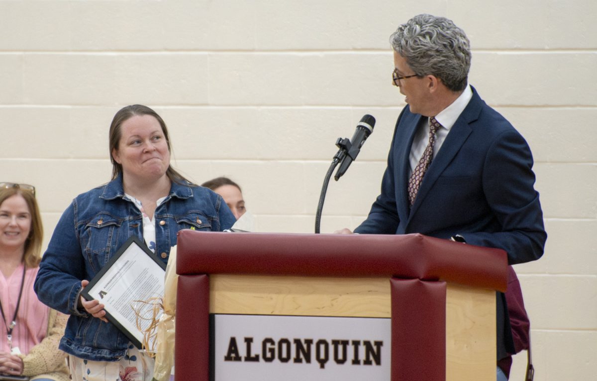 Applied arts teacher Susan Muise accepts the Pat Carlson award from Principal Sean Bevan during the Teacher of the Year assembly on May 8.