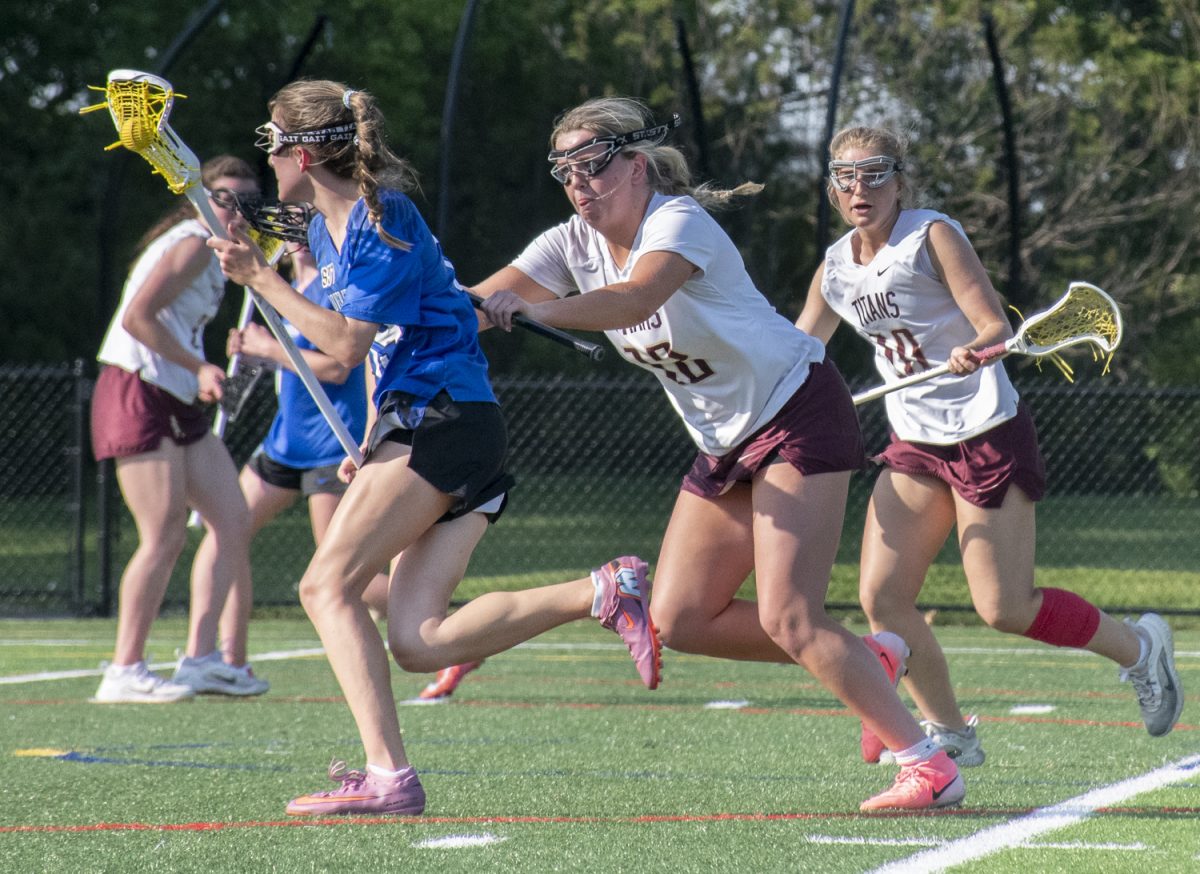 Senior Hope Candela and junior Shea Domolky pursue a Dover-Sherborn attacker near the crease during the girls’ lacrosse game on May 18.