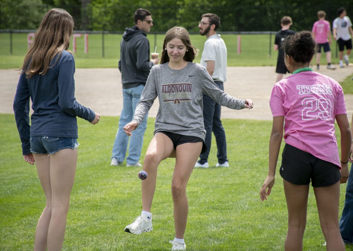 Freshmen Katelyn Costa, Violet Rea and Emily Van Niekerk play with a hacky sack at Carnival on May 22. The event takes place at the end of May each year and features food trucks, club vendors and yard games to celebrate the senior’s last day at Algonquin. 