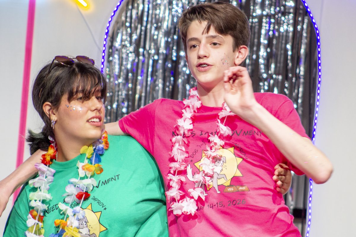 Freshman Julieta Bazterra and sophomore Milo Holtschlag act as conjoined twins while playing Embellishment during the Dog Days of Improv show on May 15. In this game, the actors must act out roles chosen by the audience and when a bell is rung must embellish their last spoken sentence.