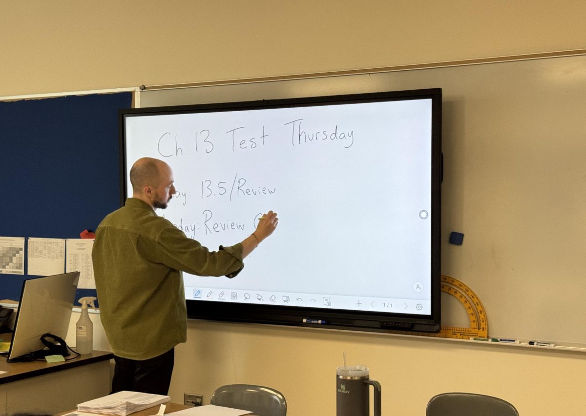 Math teacher Christian Austin uses an interactive screen in his Geometry class on May 29 to write out a review schedule for an upcoming test. 