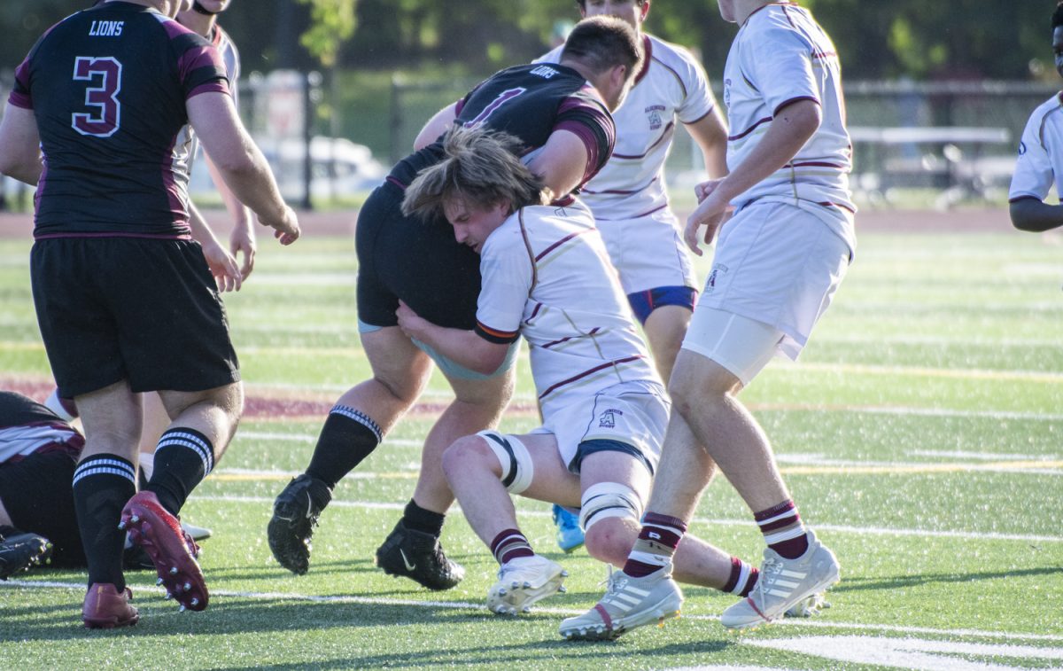 During the boys’ rugby game on May 28, junior Wyatt Smith brings down a Chelmsford opponent.