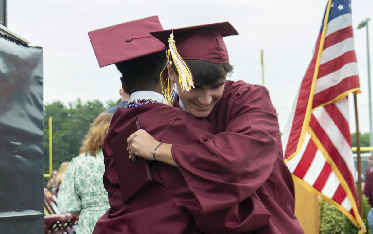 Seniors Gilbert Prepetit and Derek Pryor embrace after receiving their diplomas at graduation on June 6.